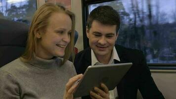 Freunde lachen, während sie Pad im Zug benutzen video