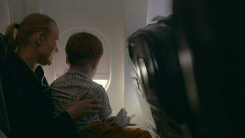 Boy and mother looking outside through plane window video