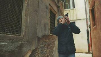 turista con retro cámara disparo al aire libre en Venecia video