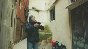 Jeune homme en marchant Extérieur et tournage avec rétro caméra video
