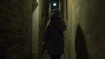 Woman running in narrow street at night video