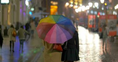 ville marcher en dessous de coloré parapluie dans pluvieux soir video