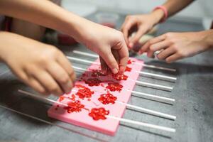 process of making delicious lollipops by pouring them into molds photo