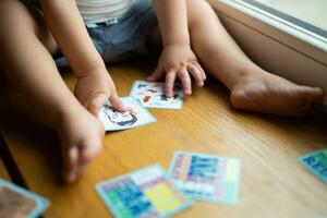 un pequeño niño obras de teatro con desarrollando tarjetas desde un tablero juego foto