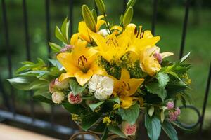 a bouquet of beautiful yellow flowers in a vase outdoors photo