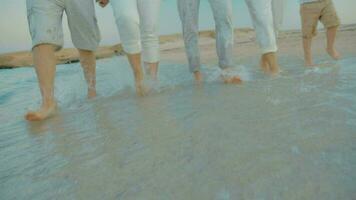 Four people splashing sea water with feet video