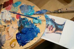 de cerca de un cepillo y un paleta con mezclado petróleo pinturas en un del artista estudio foto