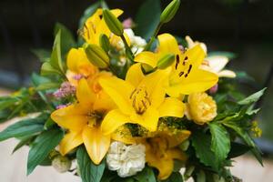 a bouquet of beautiful yellow flowers in a vase outdoors photo