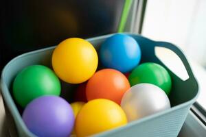 children's toy colored plastic balls in a basket photo