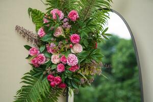 a bouquet of beautiful pink rose flowers with fern leaves near the mirror photo