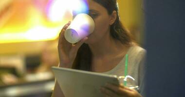 mujer amigos utilizando tableta ordenador personal y comiendo pastel en café video