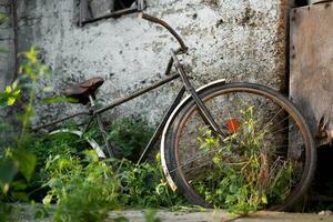 antiguo retro bicicleta en el patio interior cerca el cobertizo foto