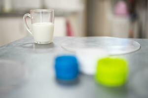 un vaso de Leche en el mesa de un cocinar preparando pasteles foto