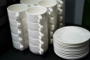 many clean white cups and plates on the table photo