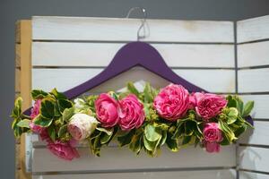 a bouquet of beautiful pink rose flowers woven into a clothes hanger photo