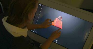 donna visualizzazione 3d modello di un' Borsa su grande toccare schermo video