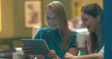 vrouwen in café lachen om iets in tablet pc video