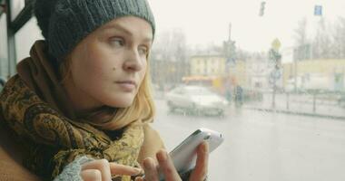 mulher mensagens de texto em célula telefone durante ônibus passeio dentro cidade video