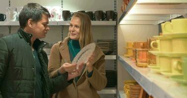 Young couple looking at dinnerware in the shop video