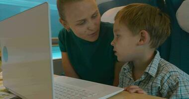 mãe e filho usando computador portátil dentro a trem video