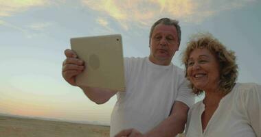 Senior couple using touch pad outdoor on vacation video