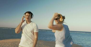 jong mensen in hoofdtelefoons ontspannende Aan strand video
