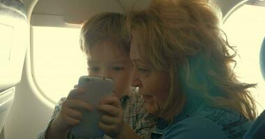 niño y abuela entretenido con teléfono en avión video