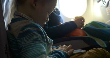 Little child in plane using smartphone video