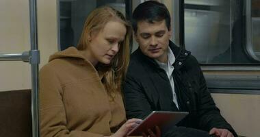 Los jóvenes con tablet PC en el tren subterráneo en movimiento video