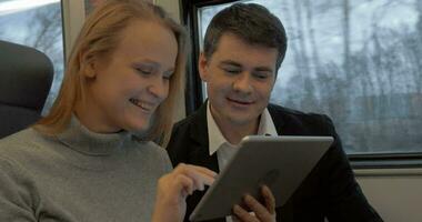 Young people working with pad and talking in the train video