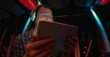 Man enjoying music with pad at sky deck at night video