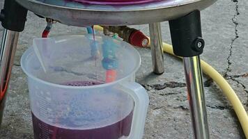 The process of making homemade grape wine. Grapes are pressed in a hydraulic press. Grape juice flows into a container. video