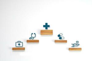 Medical icon symbol on a wooden block cube arranged in steps. Health care, health insurance and treatment  concept. photo