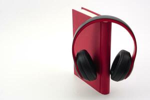 Stack of books with headphones hanging on. Modern education and relaxation concept. photo