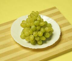 un plato de uvas en un de madera tablero foto