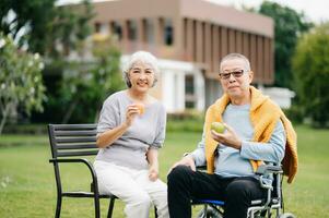 Asian senior couple having a good time. They laughing and smiling while sitting outdoor at the park. Lovely senior couple photo