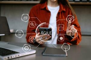 ágil desarrollo metodología concepto. negocio mano utilizando ordenador portátil computadora y tableta con virtual pantalla ágil icono en oficina digital tecnología concepto. foto