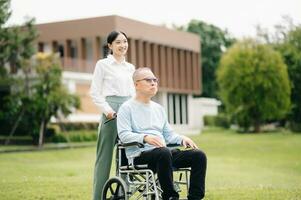 Happy adult granddaughter and senior grandfather having fun enjoying talk while relaxing sitting outdoor in the park photo