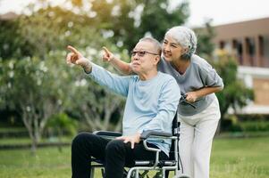 Asian senior couple having a good time. They laughing and smiling while sitting outdoor at the park. Lovely senior couple photo