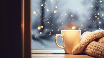 Winter holidays, calm and cosy home, cup of tea or coffee mug and knitted blanket near window in the English countryside cottage, holiday atmosphere photo