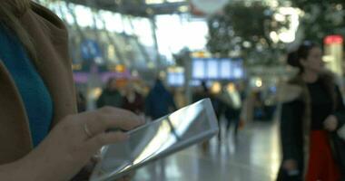 mujer gasto hora con tableta ordenador personal a el aeropuerto video