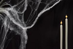 dark background for halloween. Spider web and two lit candles. Holiday decor photo