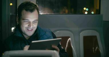 Smiling man in the bus with tablet computer video