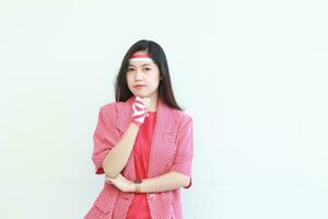 portrait of an asian woman wearing a red outfit celebrating Indonesia's independence day while thinking expression photo