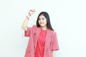 portrait of beautiful asian woman wearing red outfit posing in spirit celebrating Indonesia independence day photo