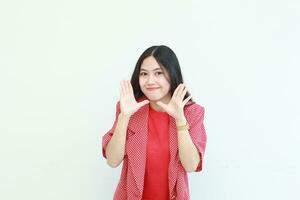 portrait of beautiful asian woman wearing red outfit with whispering gesture photo