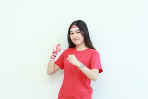 portrait of beautiful asian woman wearing red outfit posing in spirit celebrating Indonesia independence day photo