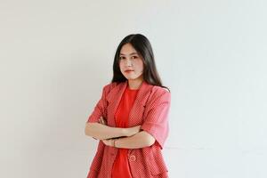 portrait of beautiful asian woman wearing red outfit with straight face gesture photo