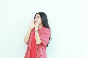 portrait of beautiful asian woman wearing red outfit with whispering gesture photo