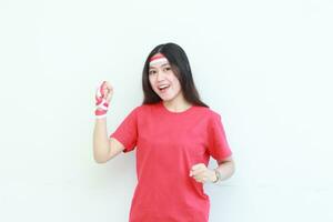 portrait of beautiful asian woman wearing red outfit posing in spirit celebrating Indonesia independence day photo